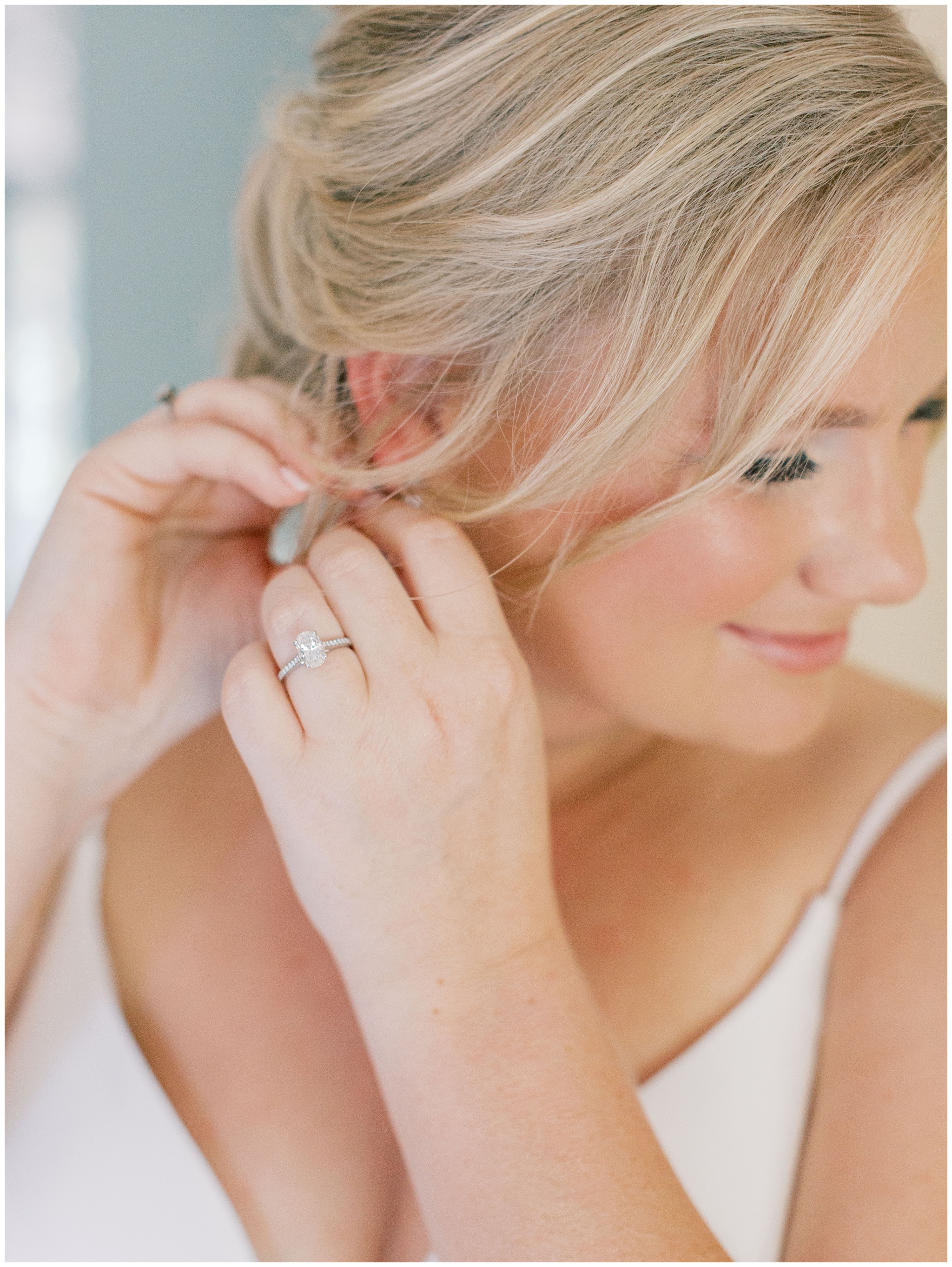 Bride putting earrings on
