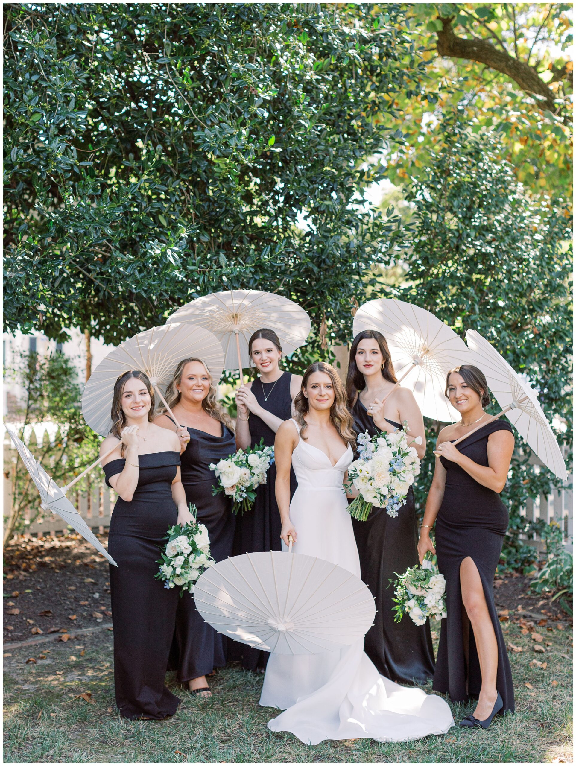 Tidewater Inn wedding bride and bridesmaids in black dresses with parasols in the garden