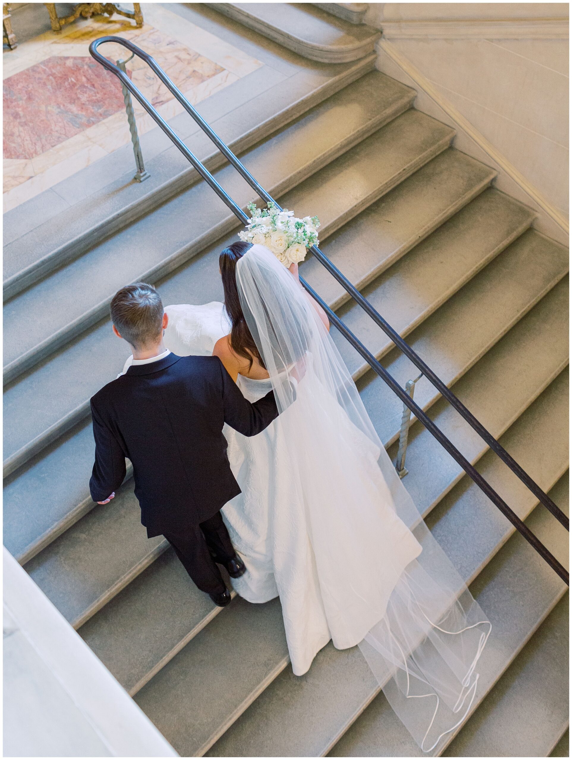 bride and groom walking up staircase in Anderson House