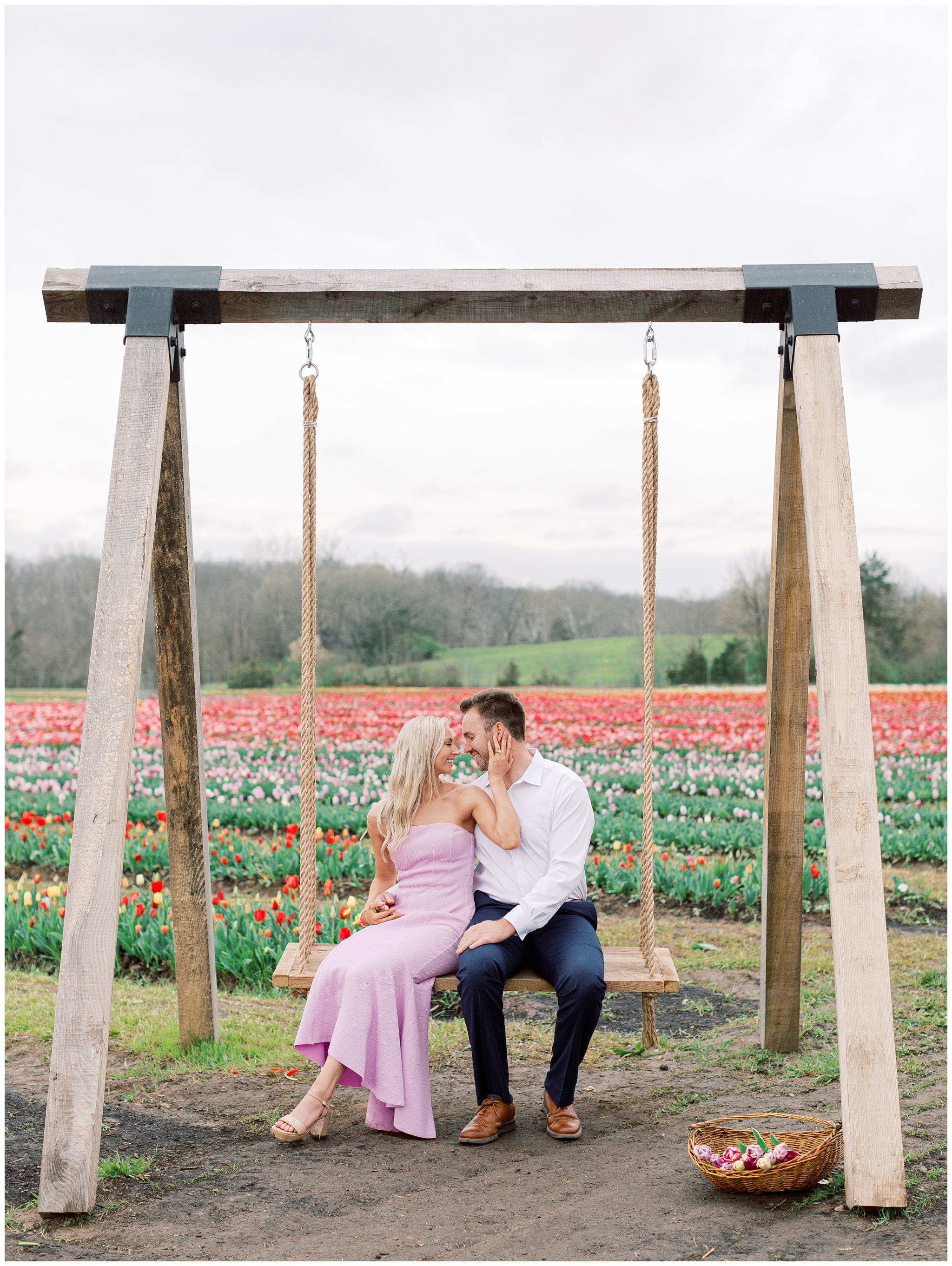 Couple sitting on a swing in the tulip fields at Burnside Farms