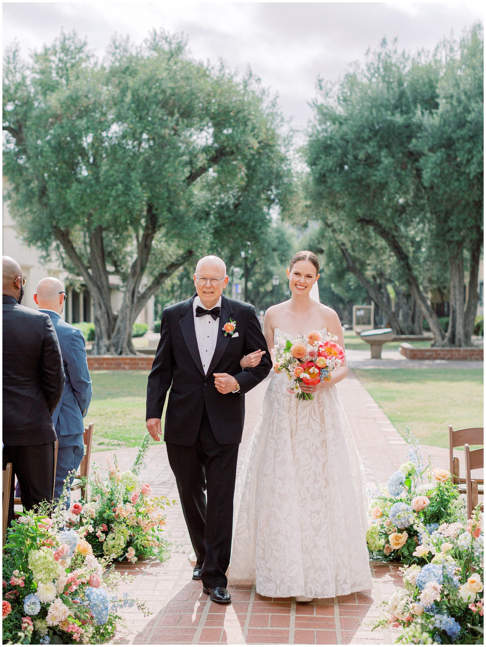 Bride walking down the aisle with her dad during Caltech Athenaeum wedding ceremony