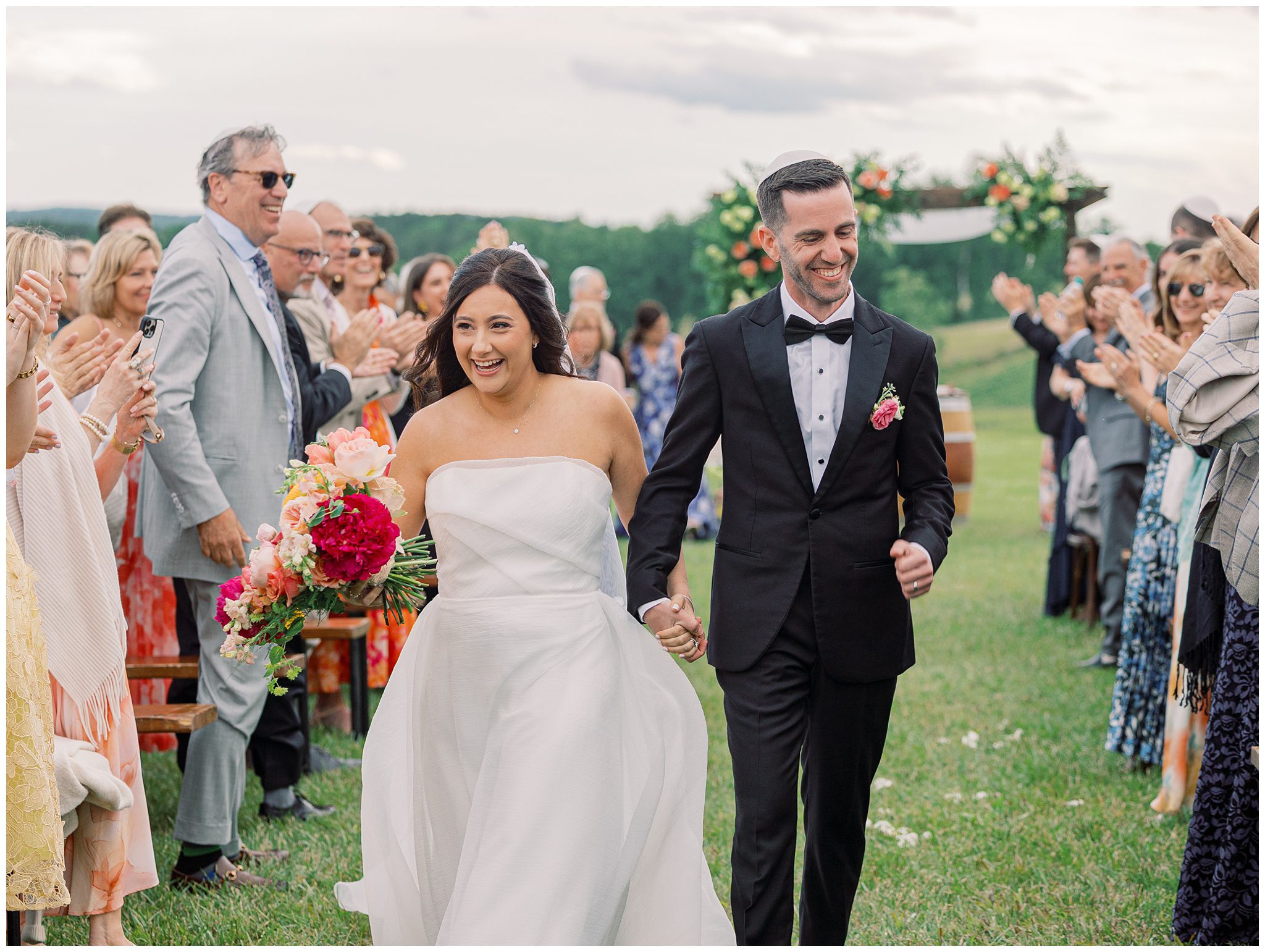 Spring wedding ceremony at Stone Tower Winery with colorful florals