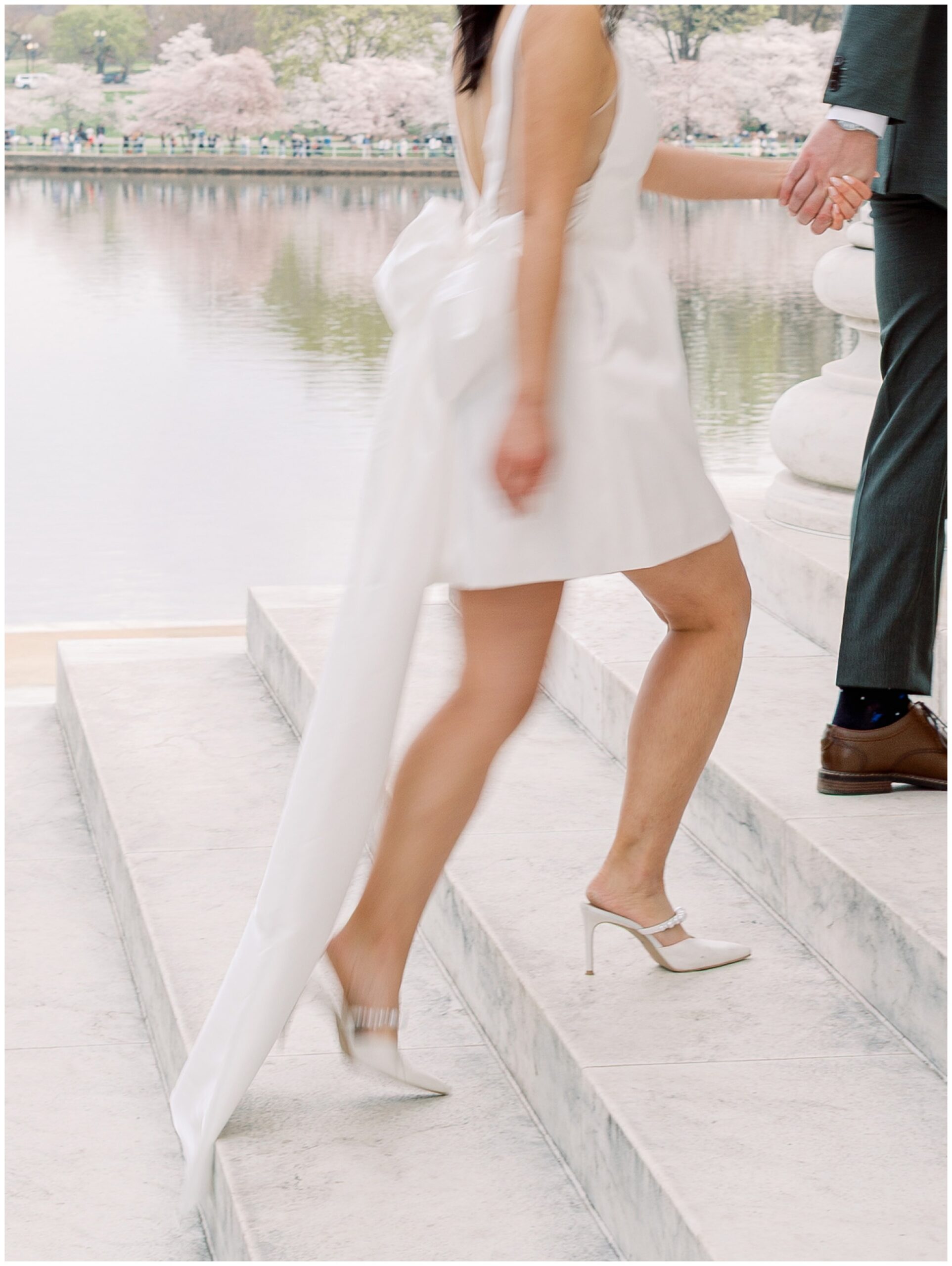 Blurry photo of couple walking up the stairs at Jefferson Memorial cherry blossom engagement