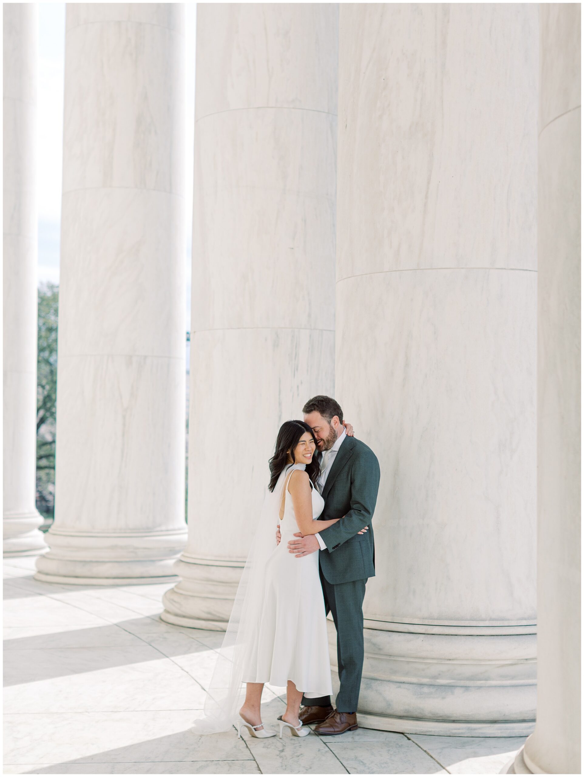 Romantic engagement portraits at the Jefferson Memorial during cherry blossom peak bloom