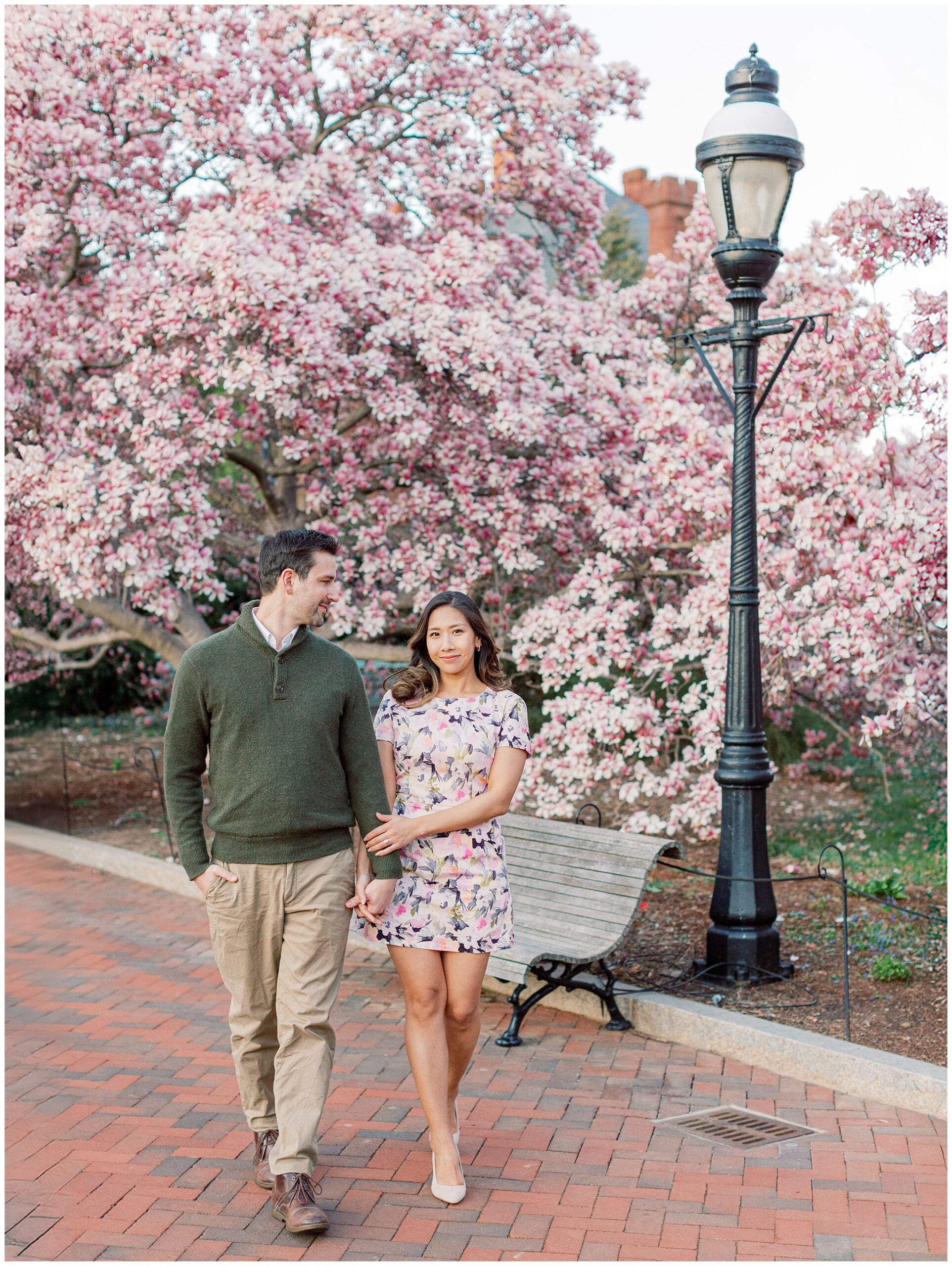 Lynette and Alex walking hand in hand through magnolias at Enid A. Haupt Garden, Washington DC