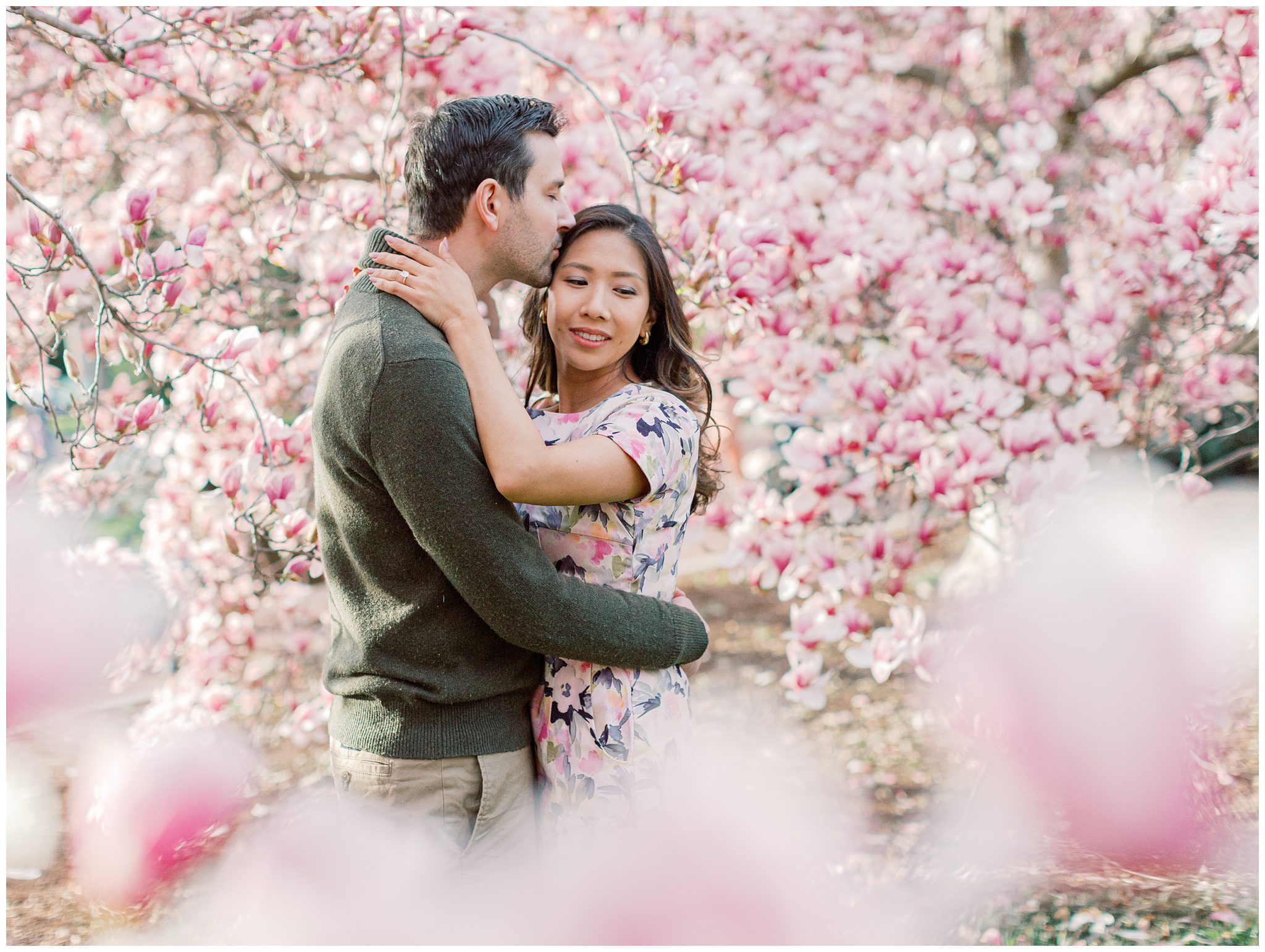 Romantic engagement portrait of Lynette and Alex surrounded by magnolia blossoms in Washington DC