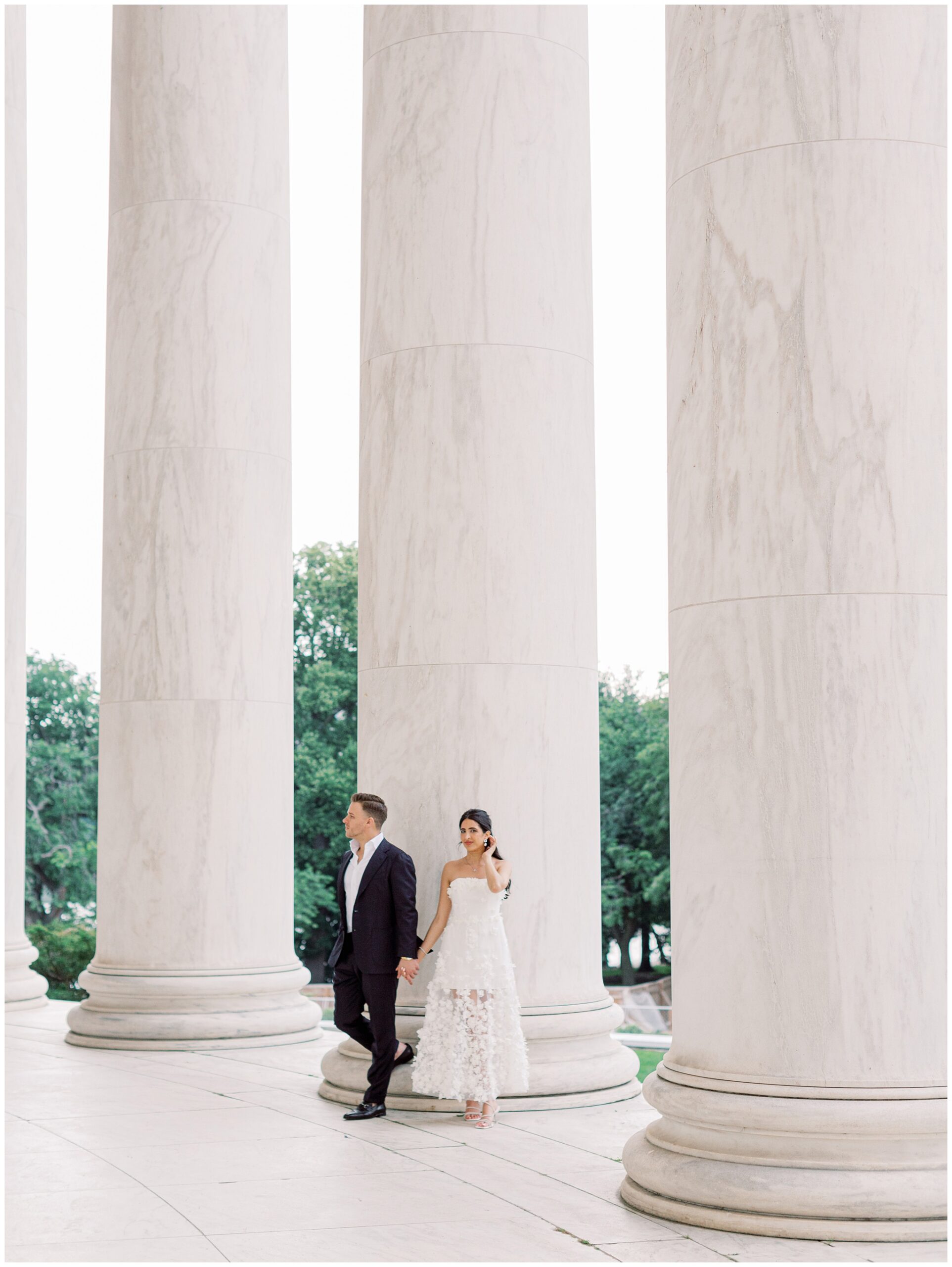 Couple posing in front of the Jefferson Memorial columns in Washington DC