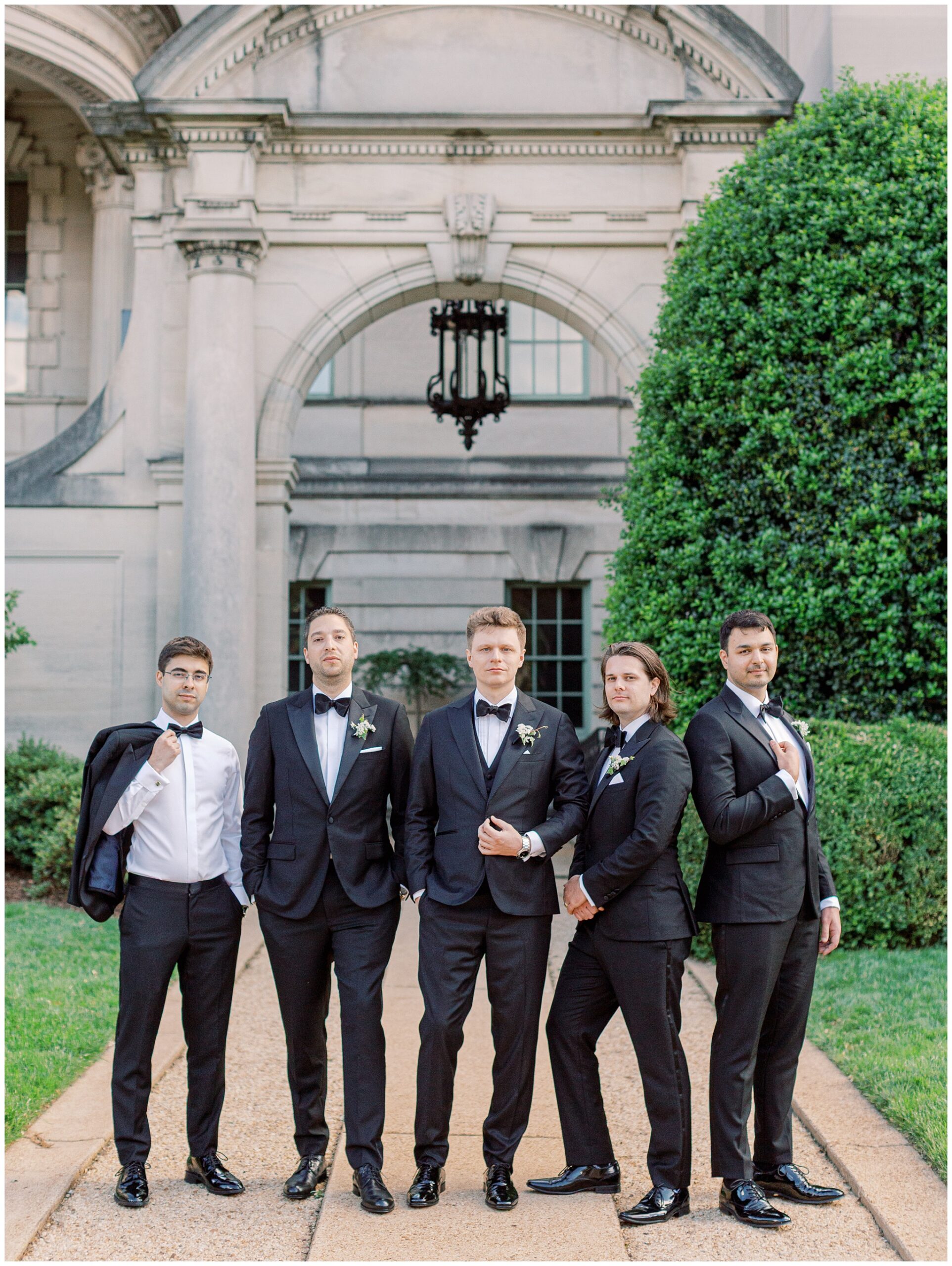 Groom and Groomsmen posing in classic black tuxedos