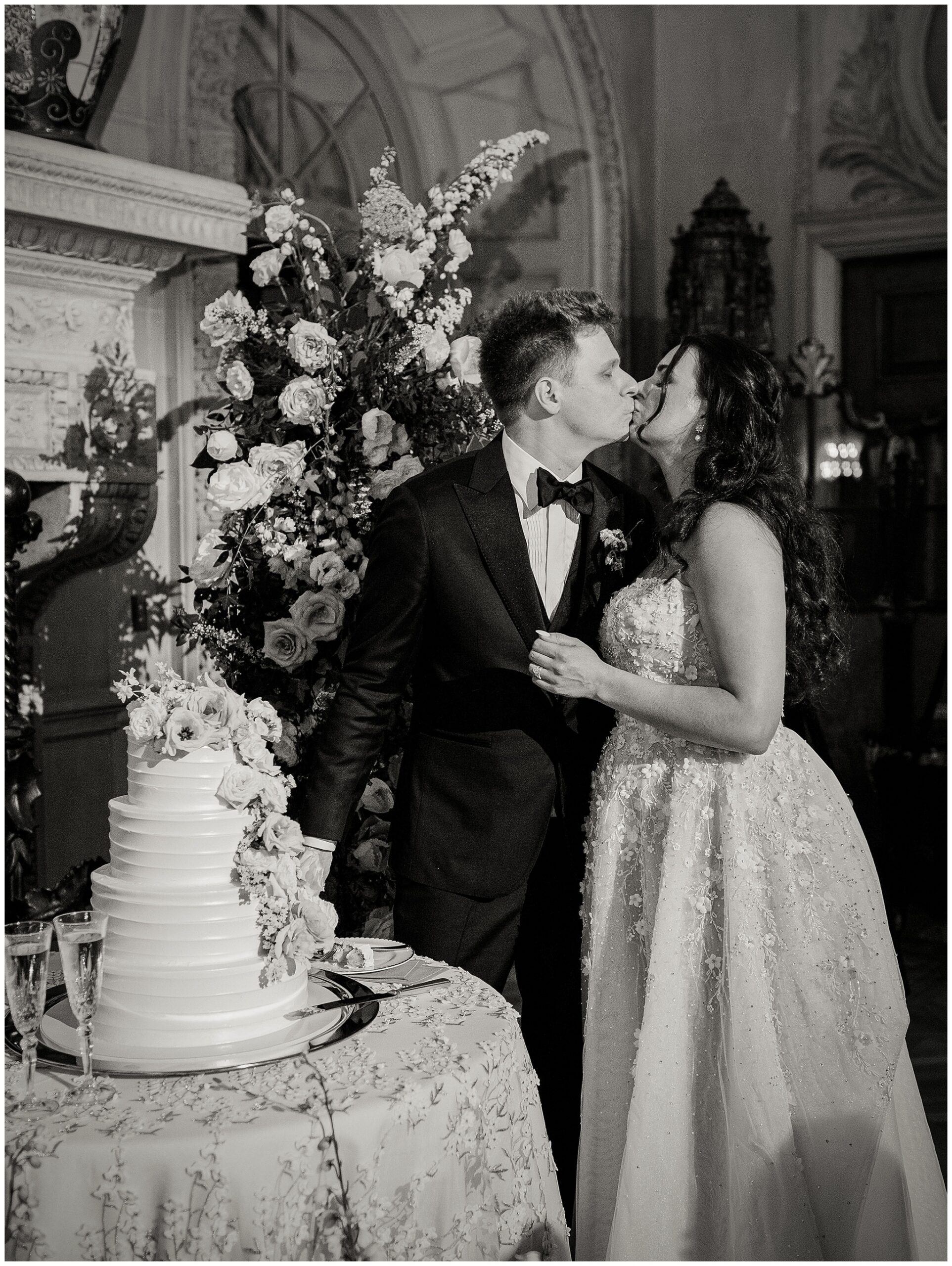 Bride and groom kissing in front of wedding cake at Larz Anderson House, Washington DC wedding