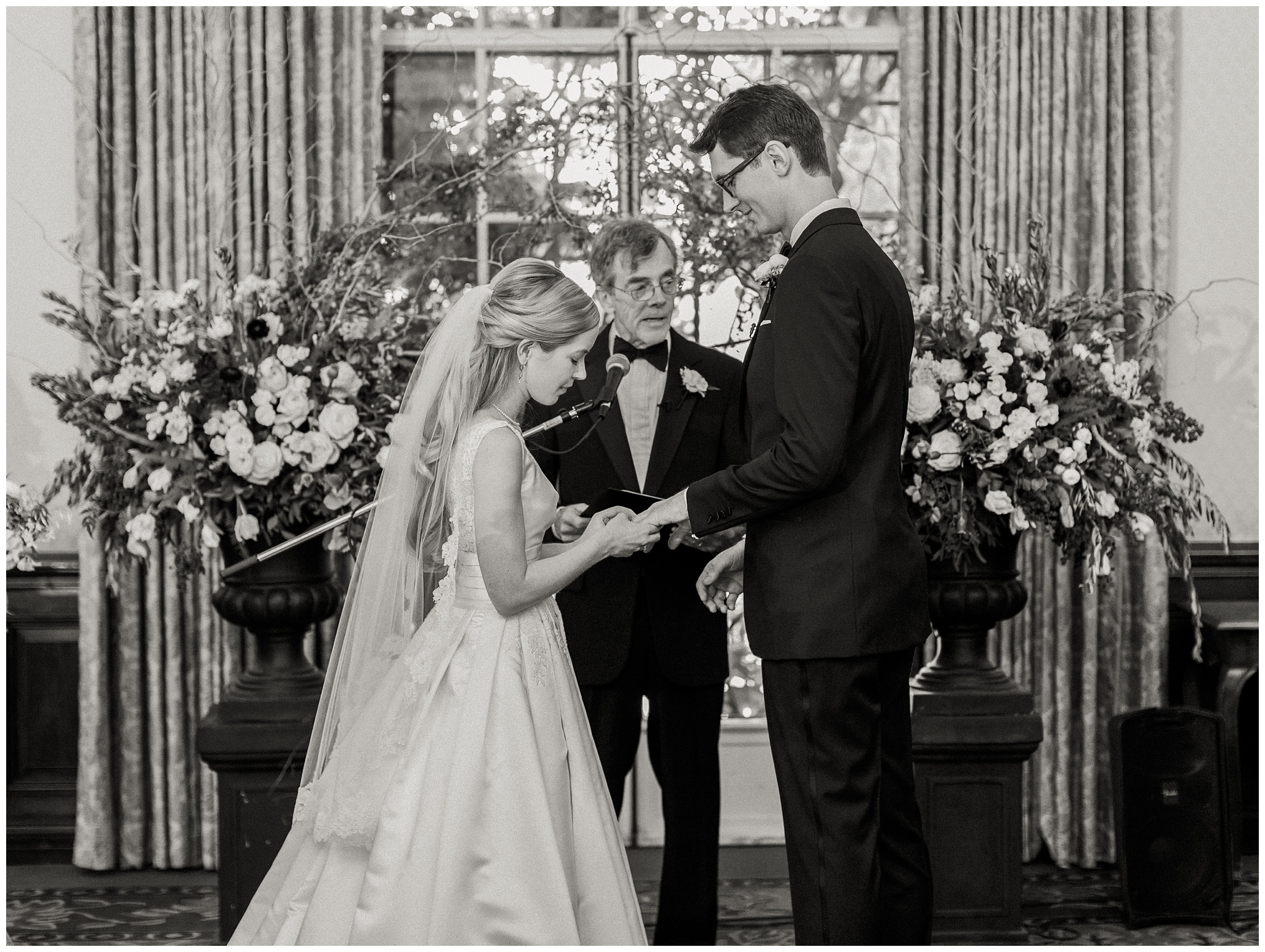Bride and groom exchanging rings during an intimate wedding ceremony in the Hall of Associates at the Caltech Athenaeum