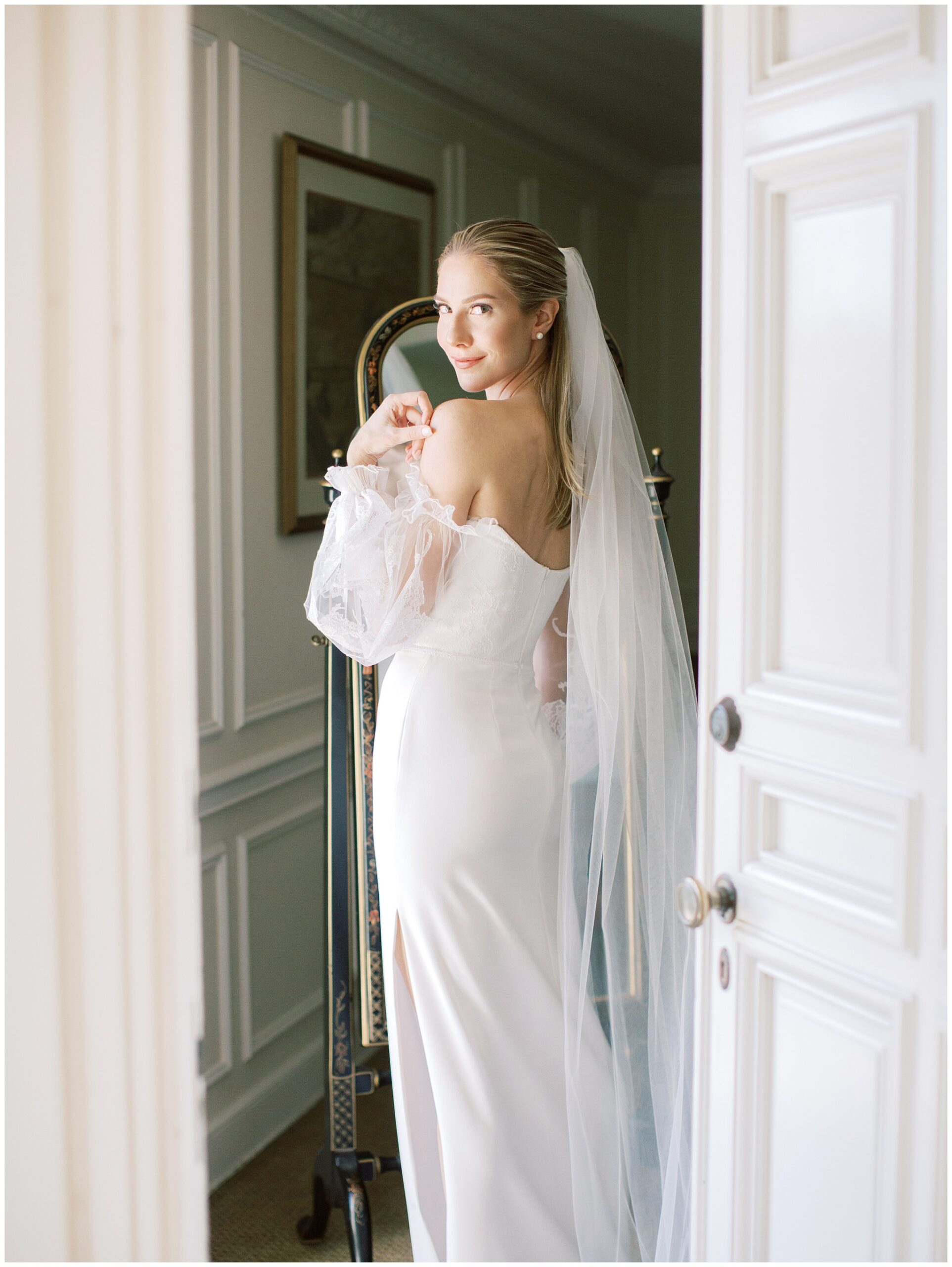 Bride looking back over her shoulder through a doorway in the Mezzanine bridal suite at the Caltech Athenaeum while getting ready for her wedding day