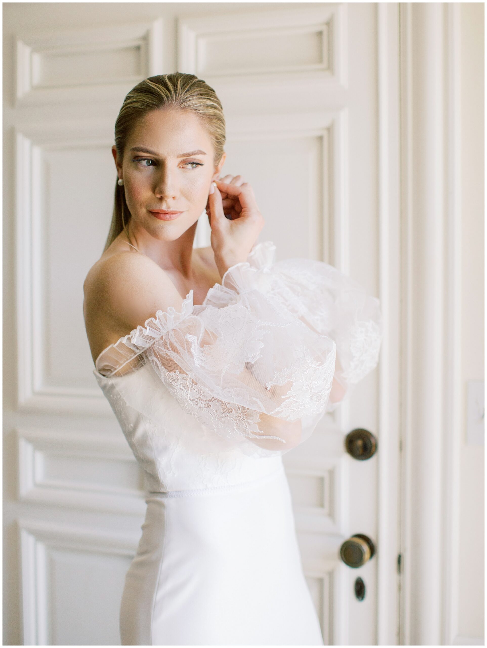 Bride putting on earrings while getting ready in the Mezzanine bridal suite before her wedding ceremony