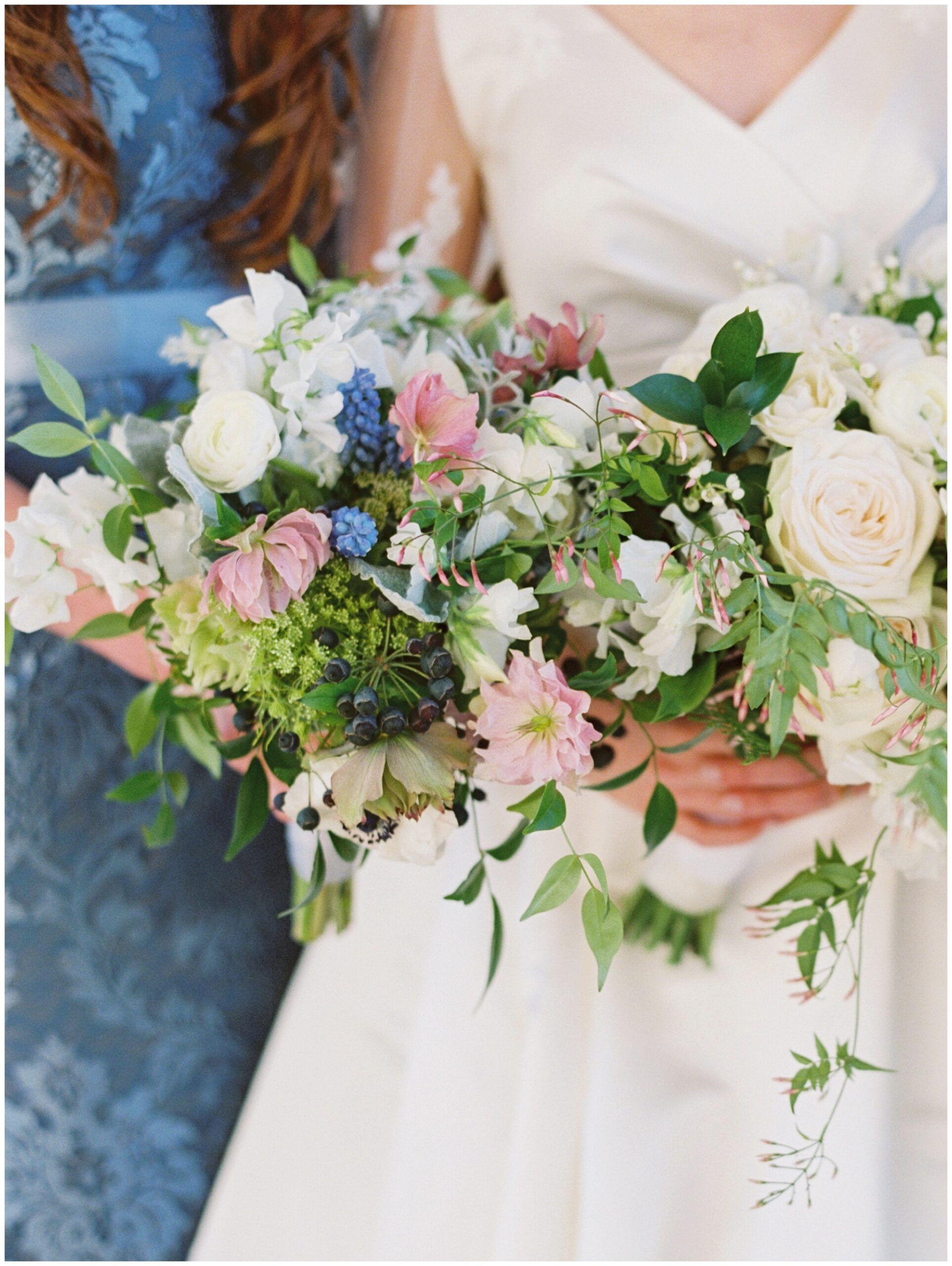 Colorful lush bridal bouquets displayed against blue bridesmaid dresses