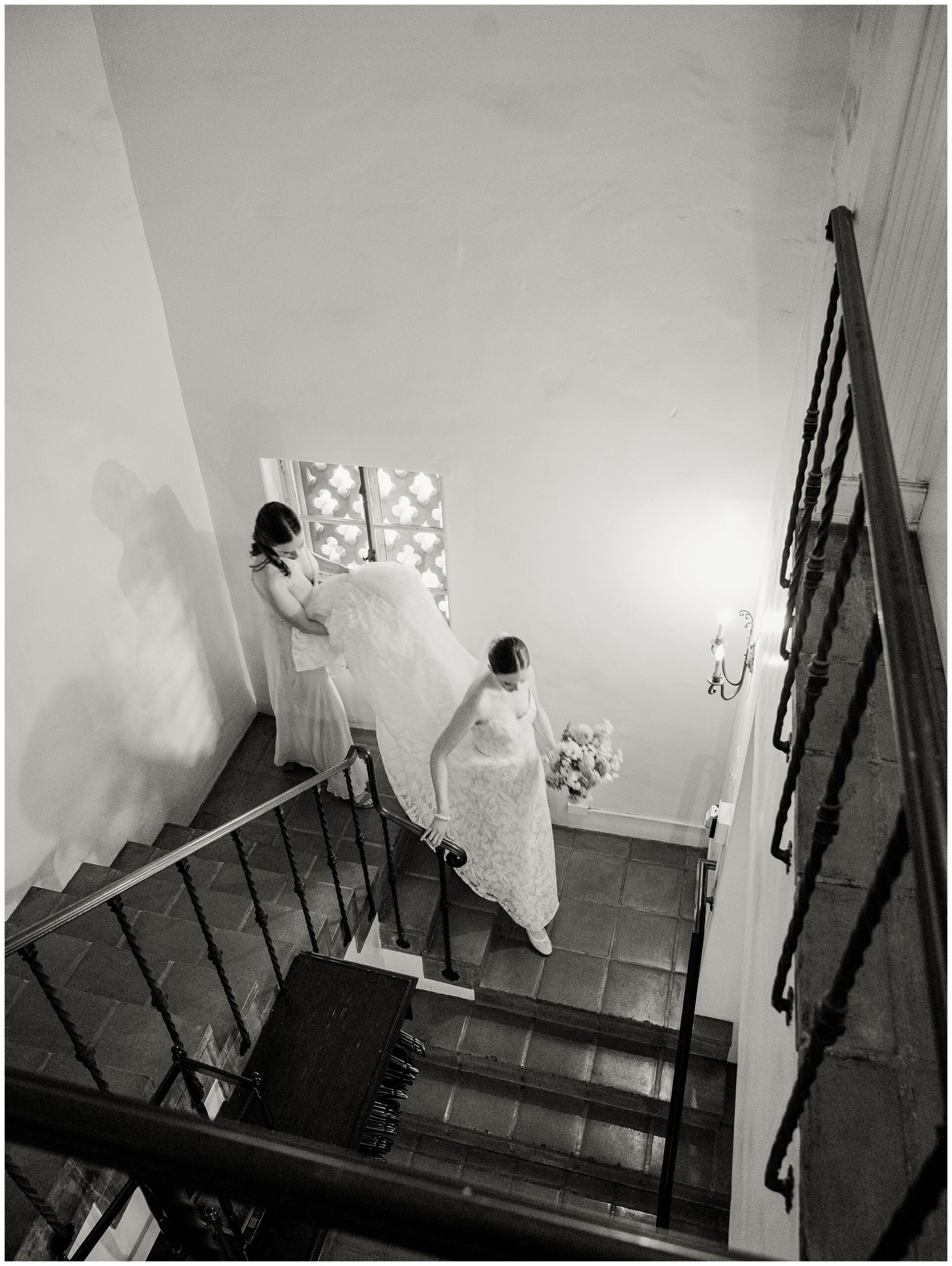 Bride and bridesmaid walking down the staircase from the Mezzanine before their wedding ceremony