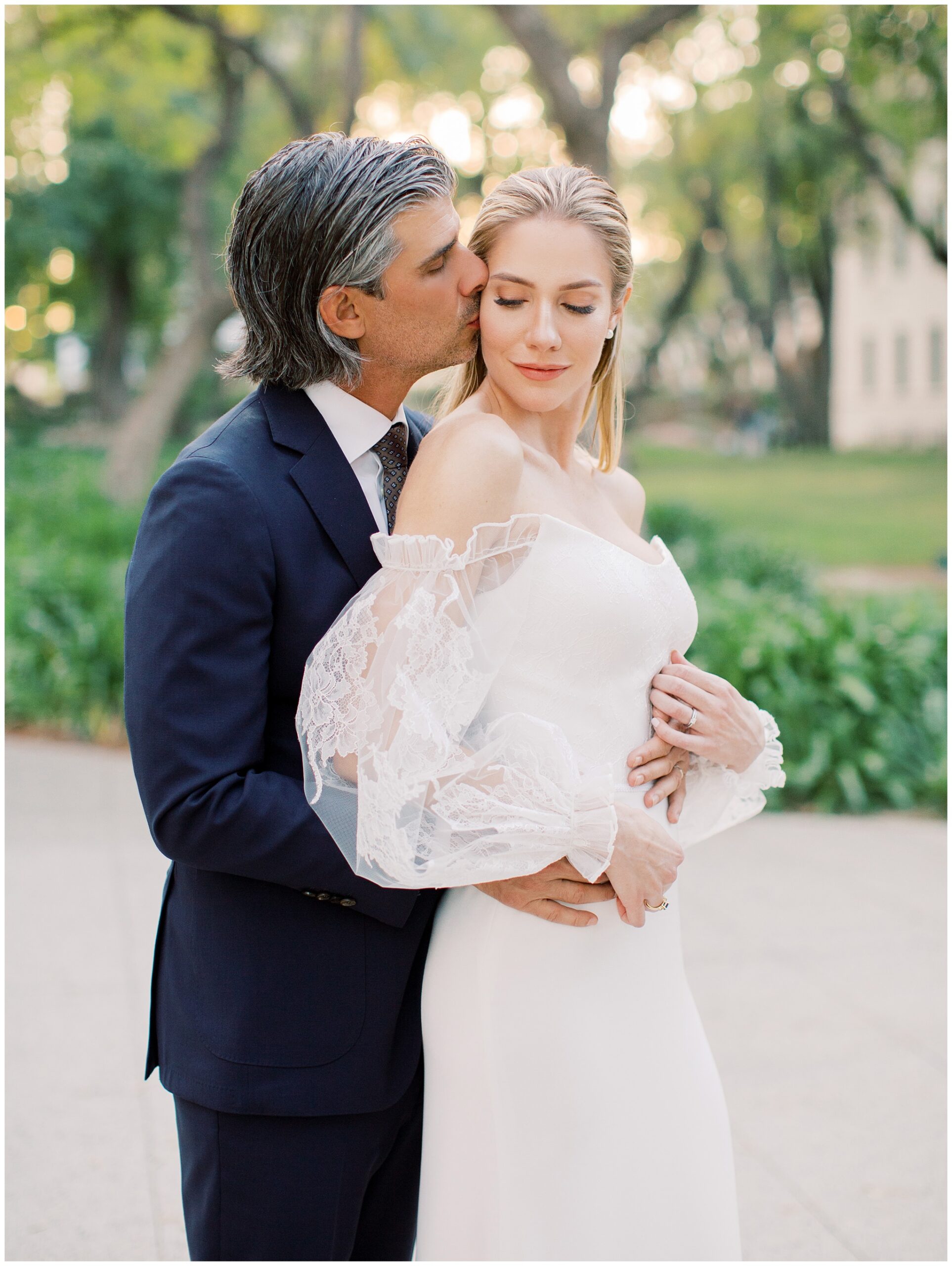 Groom kissing the bride on the side of her head during a sunset portrait as they share a quiet moment together at their Caltech Athenaeum wedding