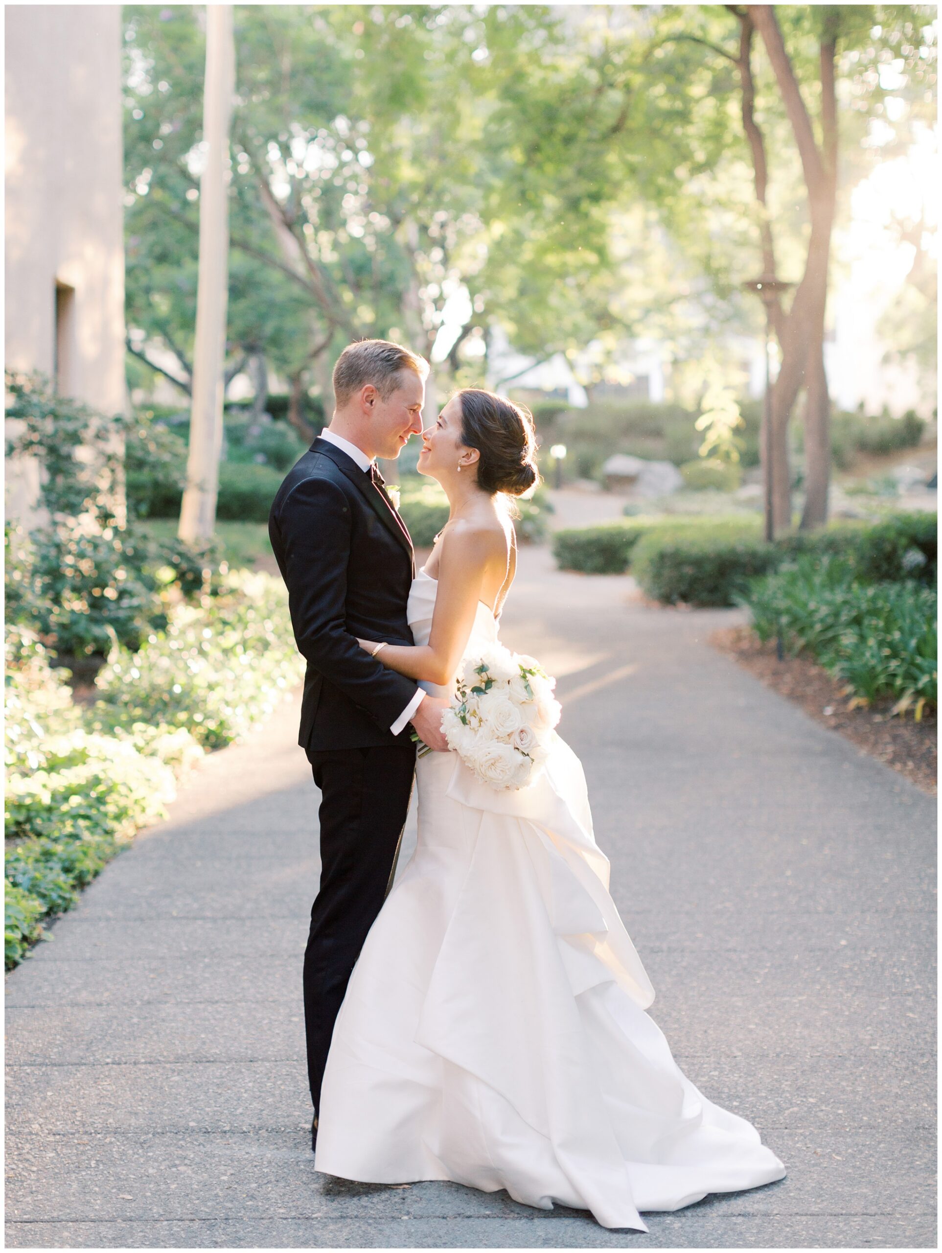 Bride and groom sharing a sunset portrait at the Caltech Athenaeum in warm golden light