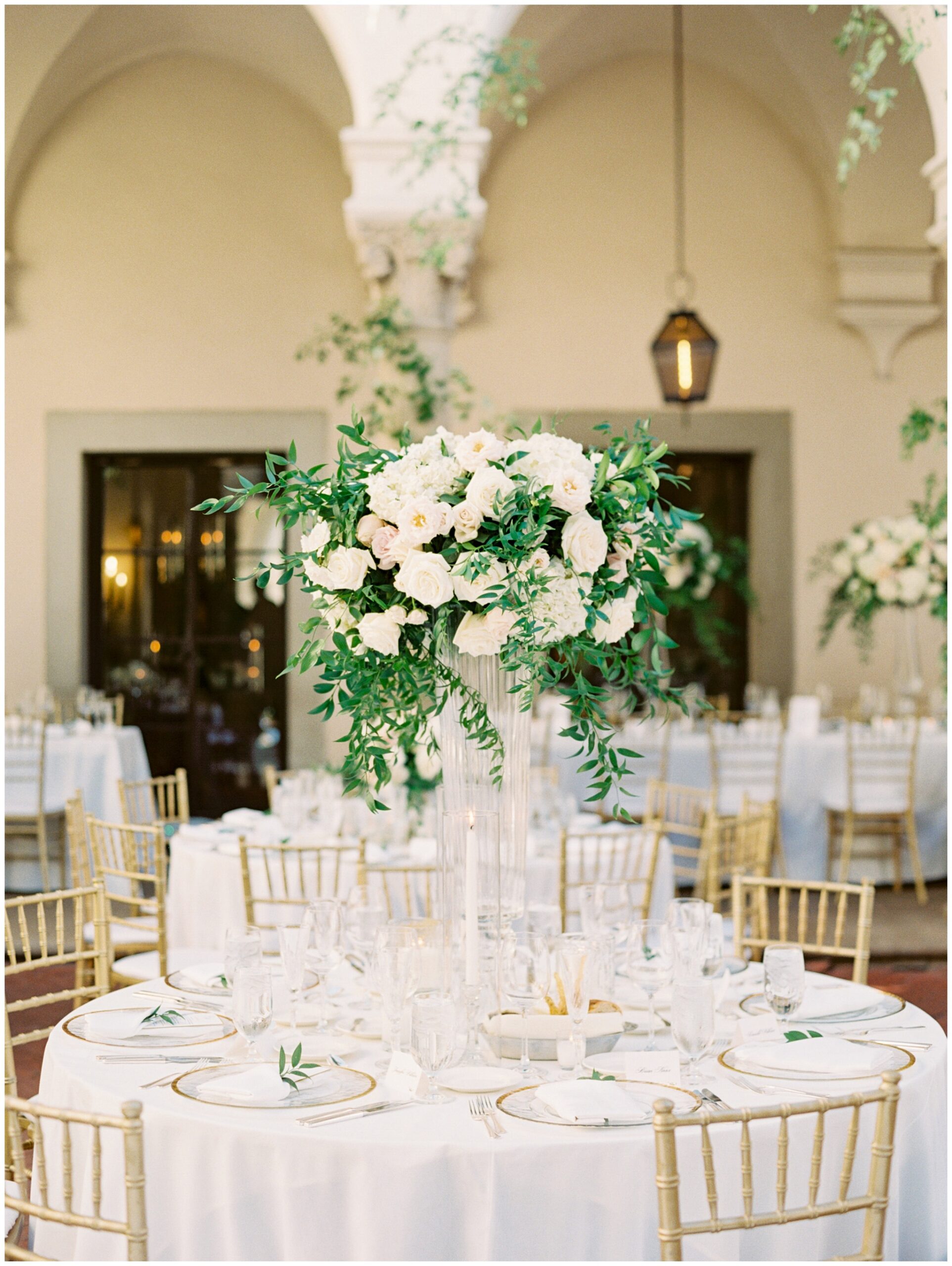 Tall floral centerpiece on a reception table at the Caltech Athenaeum featuring lush blooms and greenery