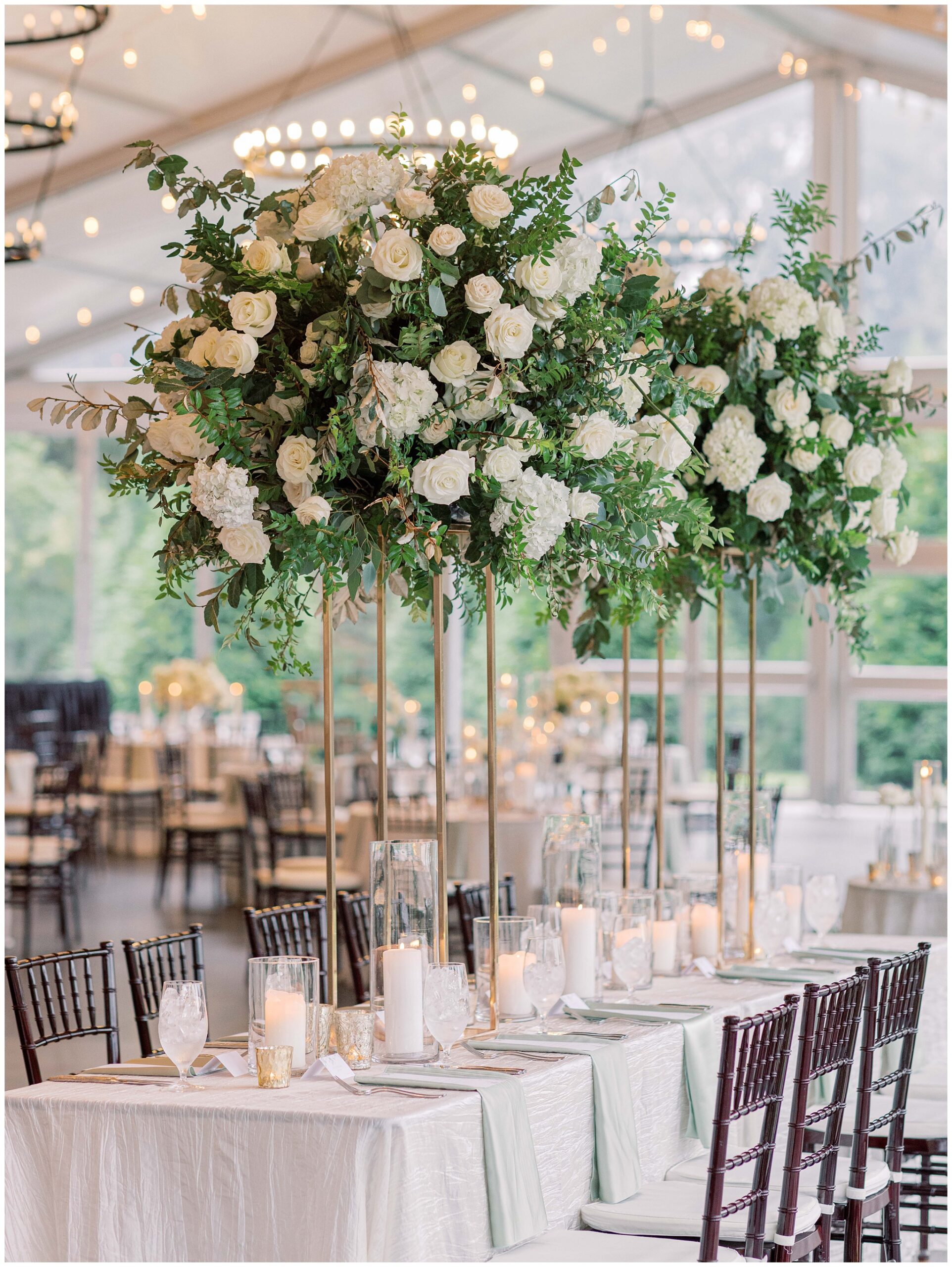 Tall floral centerpieces creating an elegant Glass Hall reception tablescape