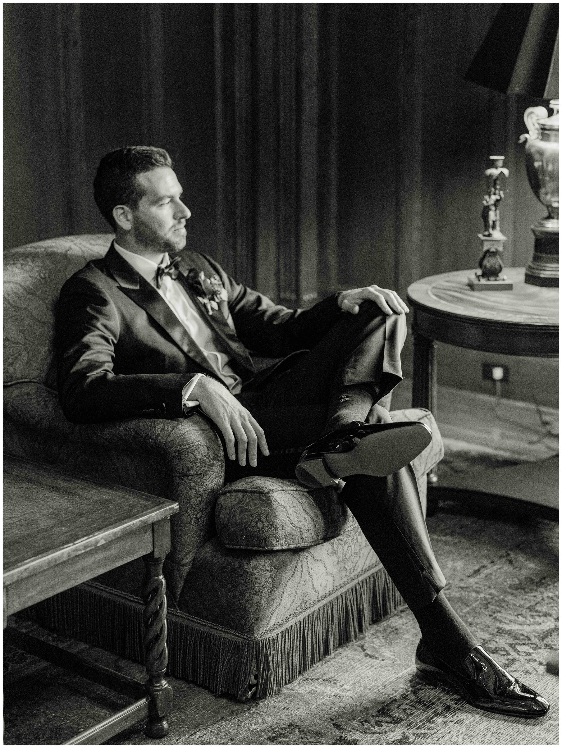 Groom posing for a portrait in an elegant Library setting