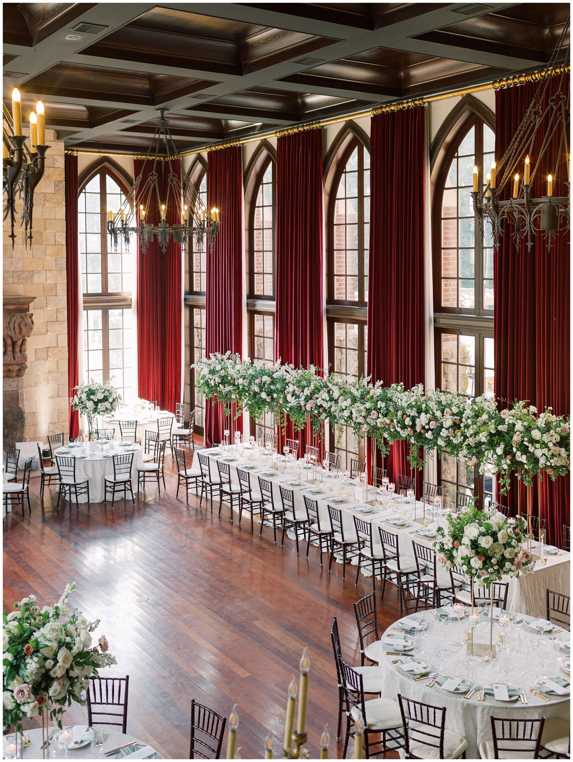 Ballroom reception space featuring lush floral arrangements throughout the room at a Dover Hall wedding
