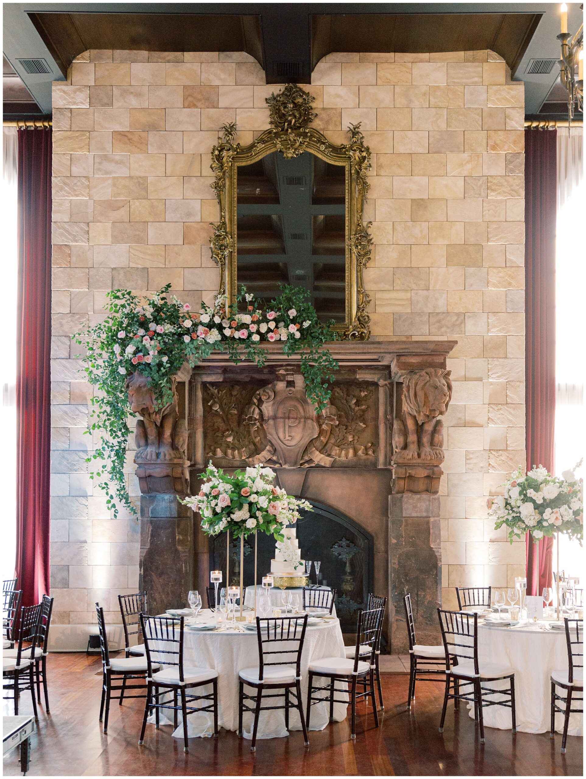 Ballroom reception tablescape with lush florals adorning the fireplace