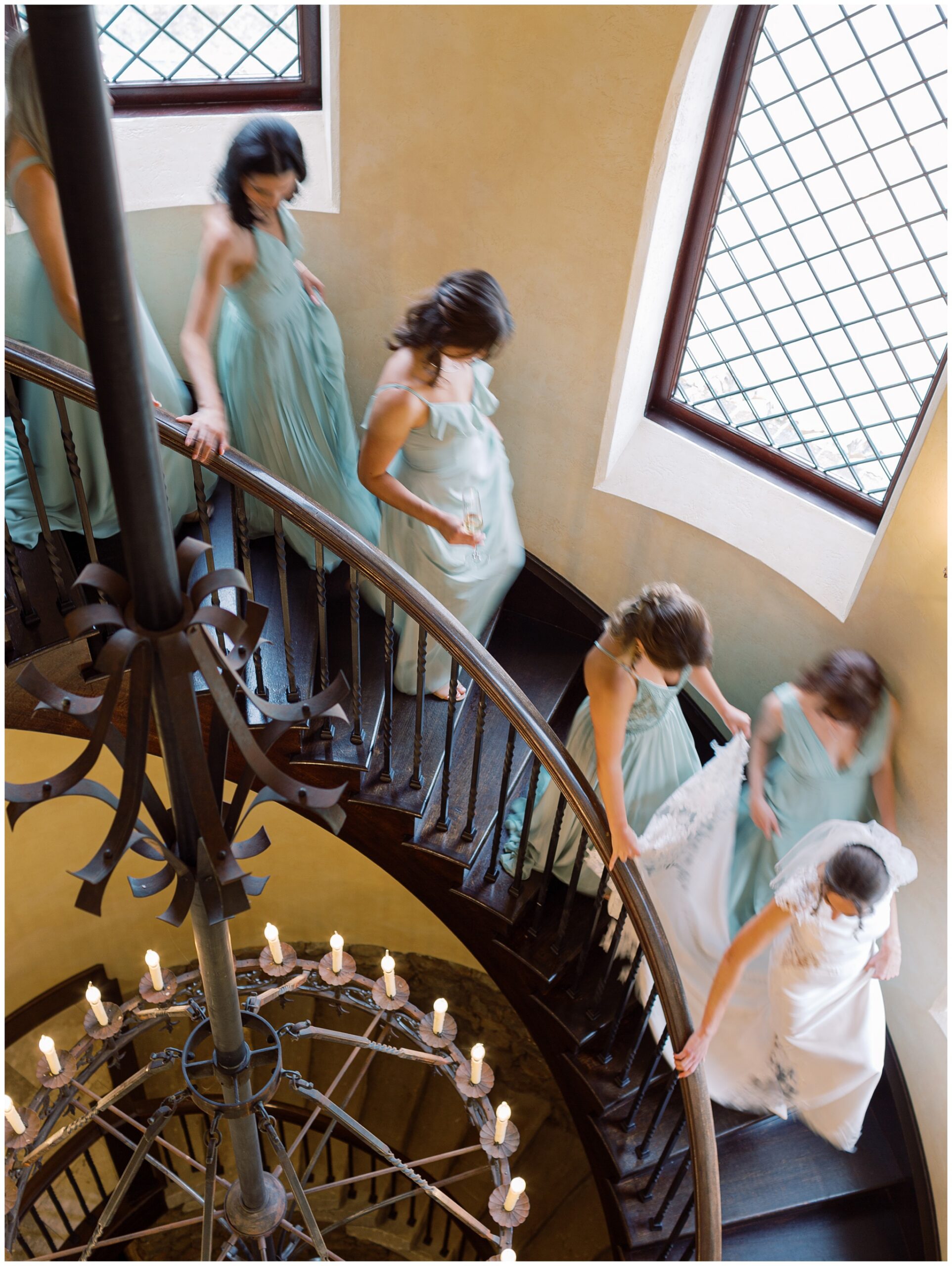 Bride and bridesmaids walking down the spiral staircase at Dover Hall with motion blur