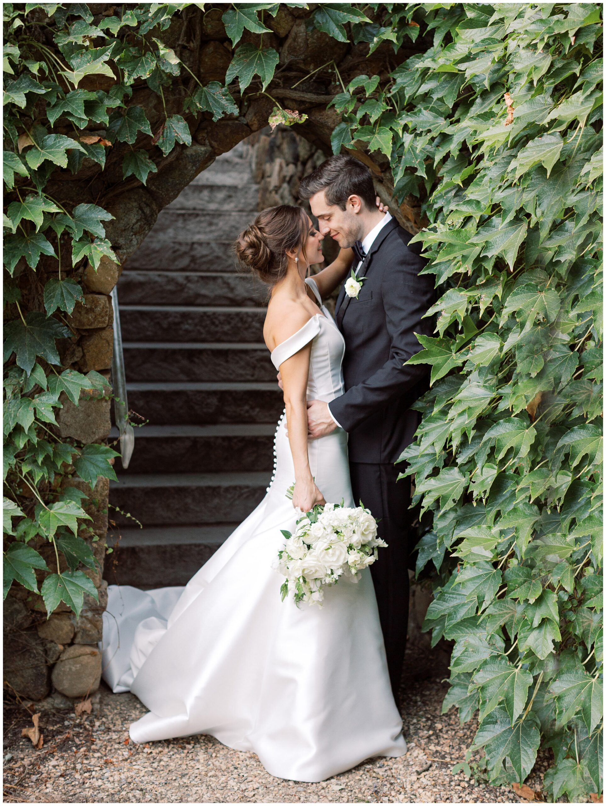 Bride and groom portrait at Dover Hall surrounded by ivy in hidden nook