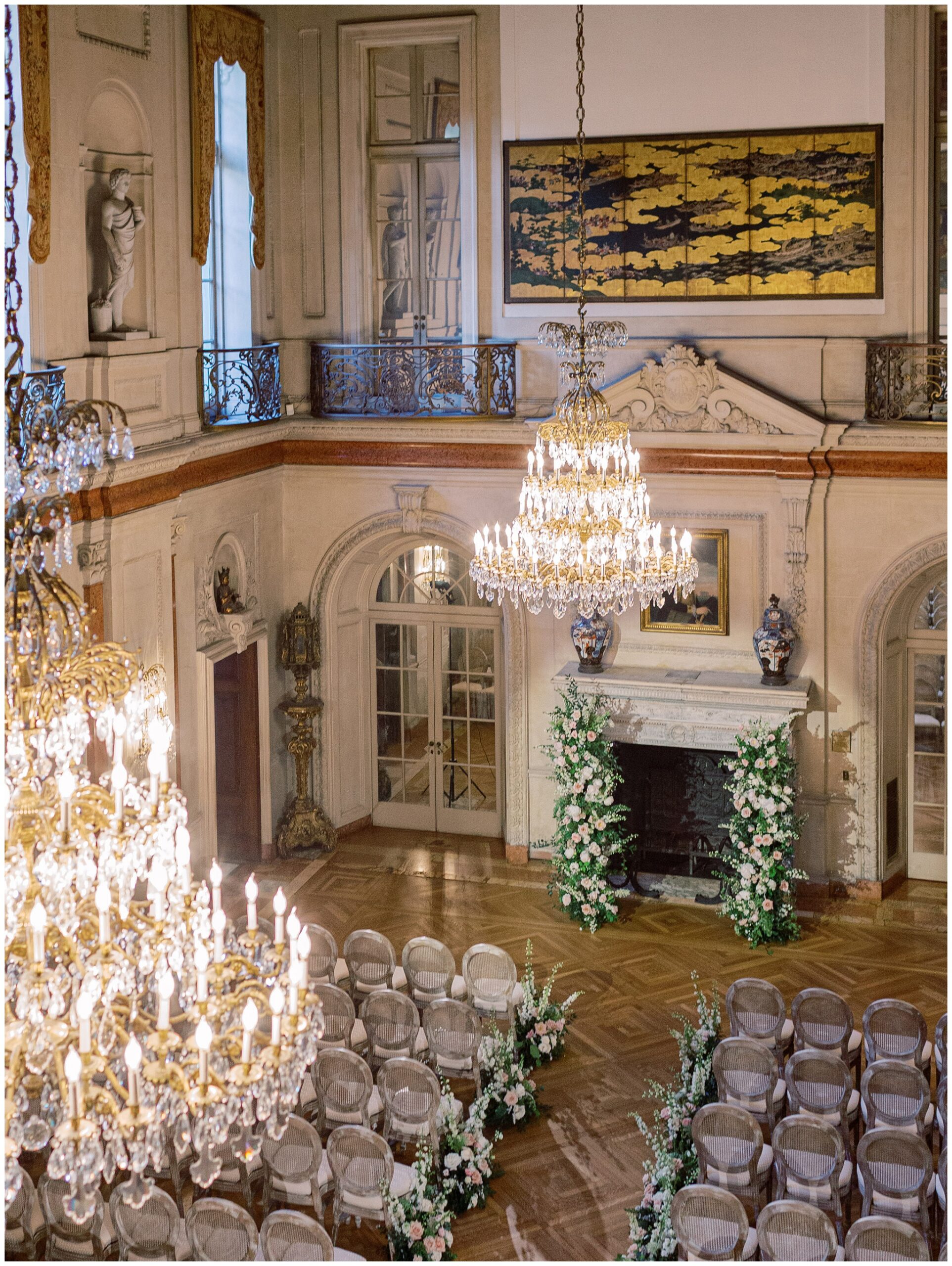 Ballroom ceremony with a floral installation over the fireplace at Anderson House