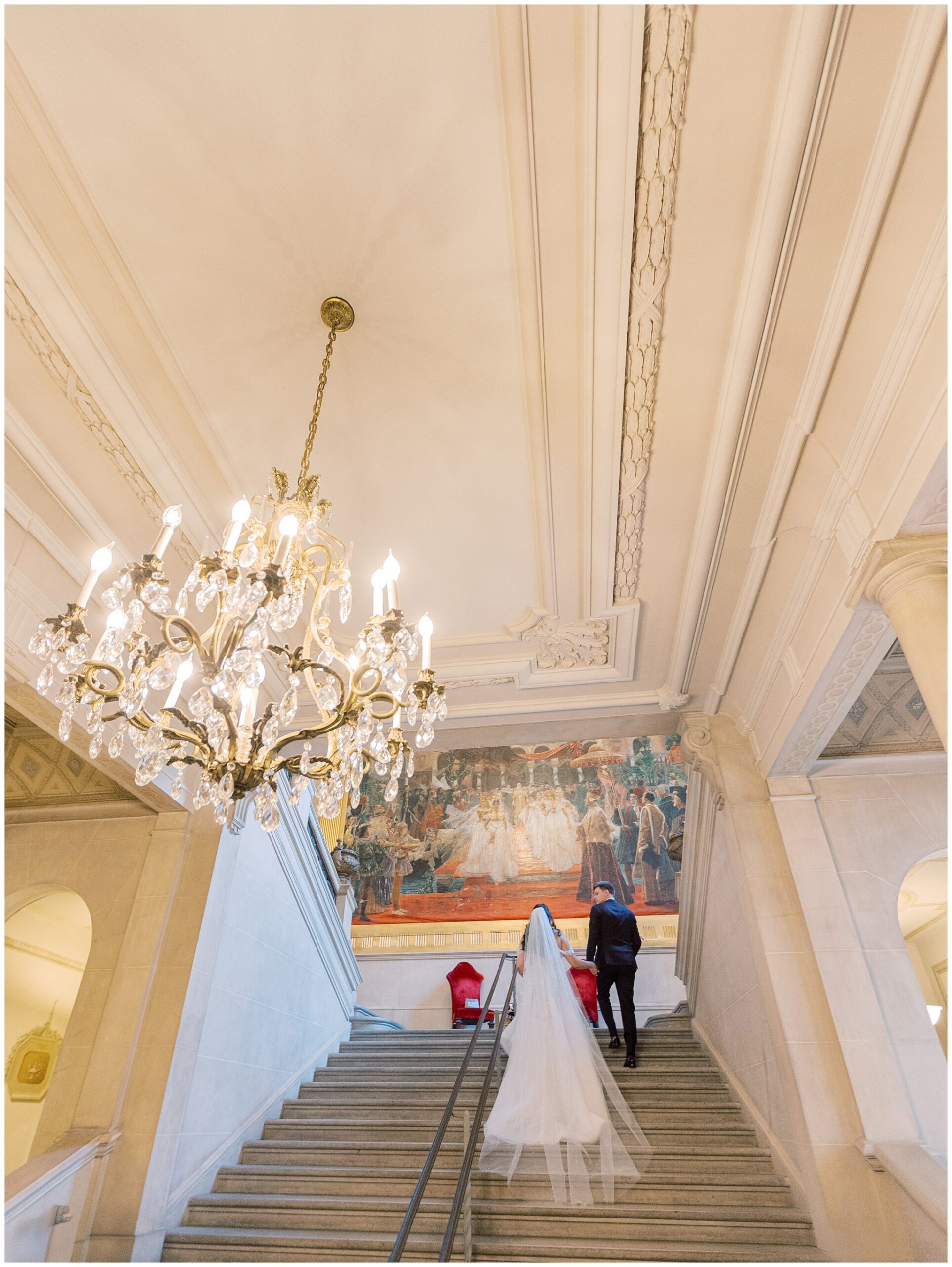 Couple walking up the Great Stair Hall staircase at Anderson House wedding in Washington DC