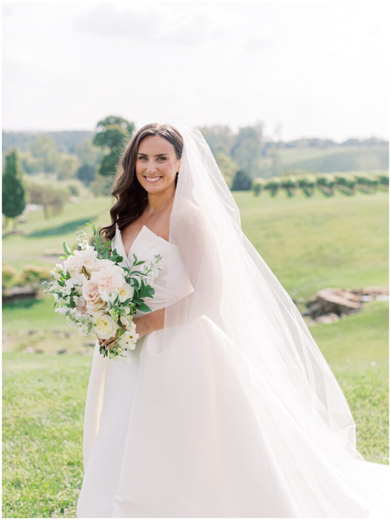 Bride standing at the Stone Circle at Stone Tower Winery with hydrangeas and mountain views behind her