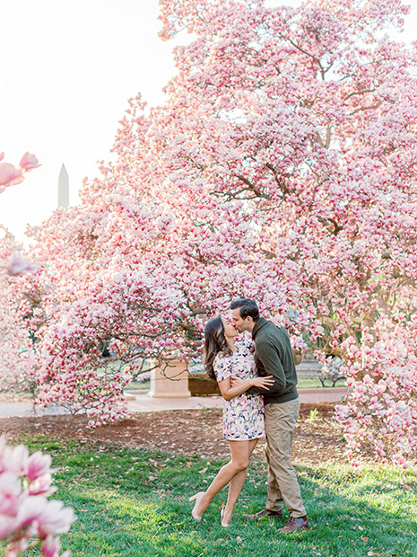 Couple kissing under magnolias in Enid A. Haupt Garden